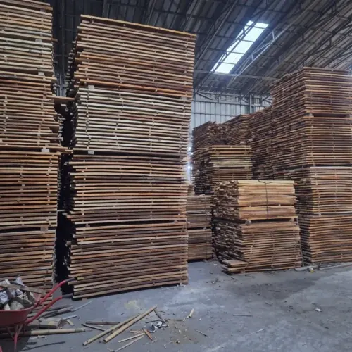 Tumpukan papan kayu yang tinggi di dalam gudang